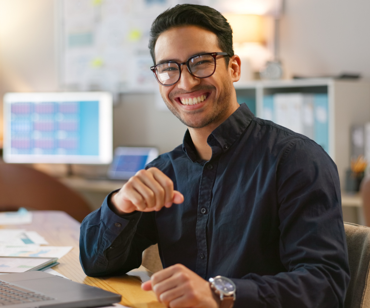 Business professional using laptop with holographic learning icons demonstrating Syspro LearnIt online education and certification platform